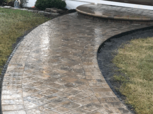 Stamped concrete walkway featuring curved design and detailed masonry solutions.