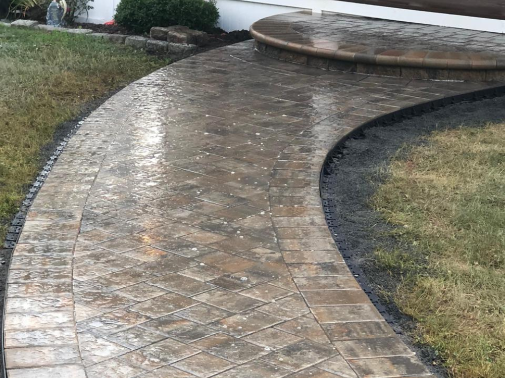 Stamped concrete walkway featuring curved design and detailed masonry solutions.