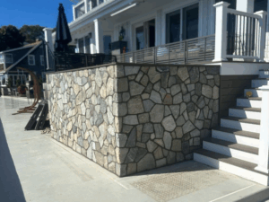 Stone wall under a deck highlighting decorative masonry solutions for modern homes.