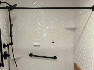 Shower with white herringbone tile pattern illustrating interior masonry solutions.