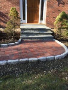 Finished front entry in red pavers with granite border and stone steps