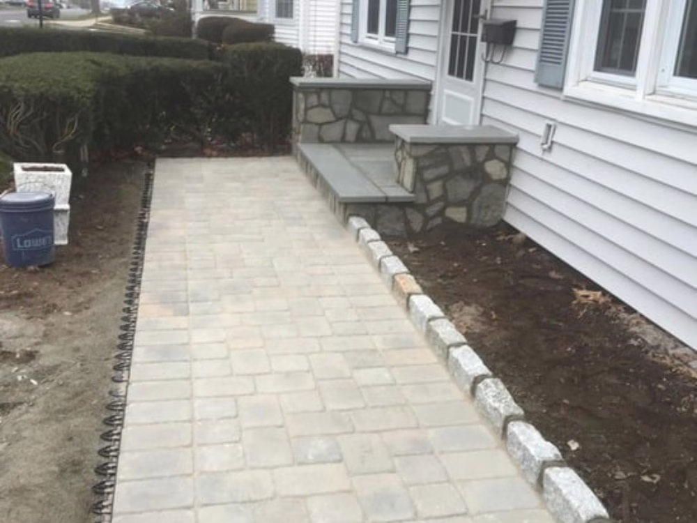 Front stone entryway renovation with stone veneer and paver integration