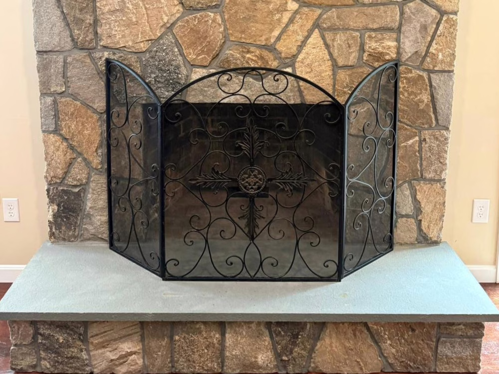 Natural stone fireplace with custom iron screen.