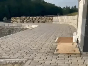 Retaining wall and paved surface by modern utility building