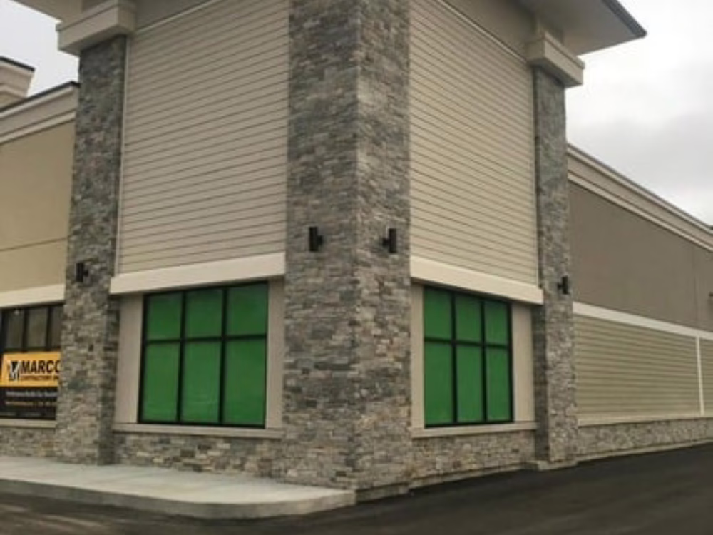 Exterior facade with stone veneer columns and modern trim detailing on a new commercial building.