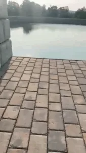 Paved walkway leading toward a pond structure