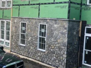 Exterior stone veneer installation on facade wall